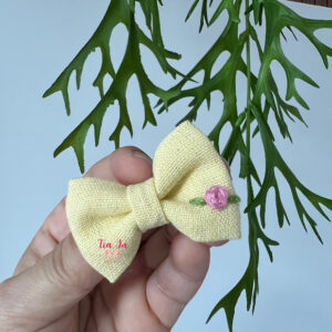 Mini laço em linho amarelo com flor rosa